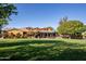 Clubhouse exterior featuring a large lawn, a stucco facade, and an outdoor pergola with seating at 15416 W Valentine St, Surprise, AZ 85379