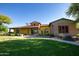 Clubhouse exterior featuring a yellow stucco facade, brick accents, and well-maintained landscaping at 15416 W Valentine St, Surprise, AZ 85379
