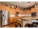 This charming kitchen features granite countertops, tile backsplash, stainless steel appliances, and light wood cabinets at 15416 W Valentine St, Surprise, AZ 85379