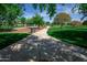 Scenic park pathway surrounded by lush green grass and mature trees, perfect for walking at 15416 W Valentine St, Surprise, AZ 85379