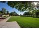 Large grassy park featuring trees, a sidewalk, green grass and an open space for recreation at 15416 W Valentine St, Surprise, AZ 85379