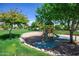 Secluded playground with a green slide and set among shade trees in a manicured green lawn at 15416 W Valentine St, Surprise, AZ 85379