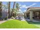 Serene backyard with lush artificial grass, pool, and patio seating, ideal for outdoor enjoyment at 15848 W Calavar Rd, Surprise, AZ 85379