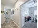 Hallway with tile flooring and a view into an office with a white board and a colorful rug at 15848 W Calavar Rd, Surprise, AZ 85379