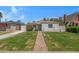 Charming single-story home features a brick pathway, lush lawn, and vibrant landscaping at 1618 W Vernon Ave, Phoenix, AZ 85007