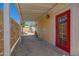 Covered outdoor patio with red door and stucco wall leads to backyard area at 1618 W Vernon Ave, Phoenix, AZ 85007