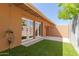 View of the private backyard with faux grass, patio, and French doors to house at 1624 E Campbell Ave # 51, Phoenix, AZ 85016