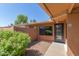 View of the home's entrance with a stone walkway, privacy wall, and desert landscaping with flowering shrubs at 1624 E Campbell Ave # 51, Phoenix, AZ 85016
