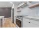 Close-up of a modern kitchen with white cabinetry, stainless steel appliances, and open shelving at 1624 E Campbell Ave # 51, Phoenix, AZ 85016