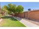 A brick wall borders the green grass lawn and walkway with shade trees offering a pleasant stroll at 1624 E Campbell Ave # 51, Phoenix, AZ 85016