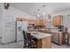 Bright kitchen featuring stainless steel appliances, wood cabinetry, an island with seating, and modern lighting at 16654 N 19Th Pl, Phoenix, AZ 85022