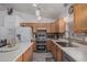 Functional kitchen space with wood cabinets, tile backsplash, stainless steel appliances, and a breakfast bar for casual dining at 16654 N 19Th Pl, Phoenix, AZ 85022