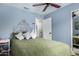Cozy bedroom with light blue walls, decorative headboard, and a ceiling fan for added comfort and style at 17128 N Princess Pl, Surprise, AZ 85374