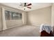 Spacious bedroom with ample natural light, carpeted floor, ceiling fan and a view of the outdoors at 17128 N Princess Pl, Surprise, AZ 85374