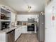 Well-lit kitchen featuring white cabinets, stainless steel appliances, granite countertops, and modern lighting at 17128 N Princess Pl, Surprise, AZ 85374