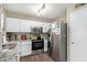 Clean, well-lit kitchen with stainless steel appliances, granite counters, and white cabinetry at 17128 N Princess Pl, Surprise, AZ 85374