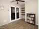 Versatile room with French doors, built-in shelves, and stylish wood-look tile flooring at 17128 N Princess Pl, Surprise, AZ 85374