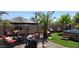 Relaxing backyard features a covered patio, hot tub, tropical trees, and comfortable outdoor seating at 18177 W Tasha Dr, Surprise, AZ 85388