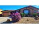 Charming single-story home with a well-maintained landscape featuring flowering shrubs and desert rock accents at 18177 W Tasha Dr, Surprise, AZ 85388