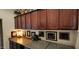 A laundry room showcases ample wooden cabinets above a counter adorned with framed pictures and a modern washing machine at 18177 W Tasha Dr, Surprise, AZ 85388