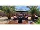Inviting backyard patio with comfortable seating, shade umbrella, and lush palm trees creating a private retreat at 18177 W Tasha Dr, Surprise, AZ 85388