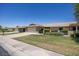 Charming single-story home with a well-manicured lawn, attached garage, and inviting curb appeal on a sunny day at 19018 N Concho Cir, Sun City, AZ 85373