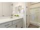 Bathroom featuring a vanity with quartz counters, mirrors, and a glass-enclosed shower at 20256 E Canary Ct, Queen Creek, AZ 85142