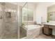 Bright bathroom showcasing a glass enclosed shower, tub, window and vanity at 20256 E Canary Ct, Queen Creek, AZ 85142