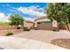 Charming single-story home features a well-manicured front yard with an expansive paver driveway and two-car garage at 20256 E Canary Ct, Queen Creek, AZ 85142