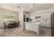 Open concept kitchen and dining area with stainless steel appliances, white island, and pendant lighting at 20256 E Canary Ct, Queen Creek, AZ 85142