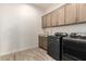 Well-equipped laundry room featuring washer, dryer, sink, and cabinet storage at 20256 E Canary Ct, Queen Creek, AZ 85142