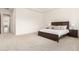 Spacious carpeted main bedroom with a wooden bed, side tables, and view of an hallway at 20256 E Canary Ct, Queen Creek, AZ 85142