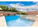 Inviting pool with a raised spa and stone accents, surrounded by a well-maintained brick fence and lush greenery at 20256 E Canary Ct, Queen Creek, AZ 85142