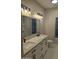Bathroom featuring double sinks, a marble countertop, modern lighting, and an elegant mirror at 20677 N 16Th Way, Phoenix, AZ 85024
