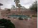 Backyard pool with rock features, mature landscaping, and desert surroundings at 20677 N 16Th Way, Phoenix, AZ 85024