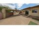 Spacious backyard with an awning patio area, brick flooring, and mature landscaping at 2222 E Gretta Pl, Phoenix, AZ 85022