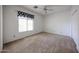 Well-lit bedroom featuring carpet floors, large window, ceiling fan, and closet at 2222 E Gretta Pl, Phoenix, AZ 85022