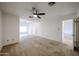 Large main bedroom offers neutral carpet, a ceiling fan, and access to the ensuite bath and walk-in closet at 2222 E Gretta Pl, Phoenix, AZ 85022
