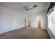 Bright bedroom featuring neutral carpet, ceiling fan, and access to closet and bathroom at 2222 E Gretta Pl, Phoenix, AZ 85022