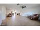 Spacious living room features tile flooring, a ceiling fan, and an open concept to the dining and kitchen areas at 2222 E Gretta Pl, Phoenix, AZ 85022