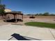 Backyard with gazebo, artificial turf, rock landscaping, and partial view of the surrounding neighborhood at 22966 W Hopi St, Buckeye, AZ 85326
