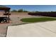 Backyard featuring a concrete patio, rock landscaping, and artificial turf at 22966 W Hopi St, Buckeye, AZ 85326