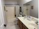 Well-lit bathroom featuring a double sink vanity, tub-shower combo, and neutral-toned tiling at 22966 W Hopi St, Buckeye, AZ 85326