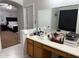 Bathroom vanity with a sink, mirror, cabinets, and a view of the bedroom at 22966 W Hopi St, Buckeye, AZ 85326