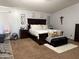 Well-lit main bedroom with a large bed, dark wood furniture, and neutral decor at 22966 W Hopi St, Buckeye, AZ 85326