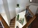 Interior staircase featuring carpeted steps, wooden railing with iron spindles, and decorative plants at 22966 W Hopi St, Buckeye, AZ 85326