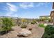 Backyard showcasing desert landscaping, a rock waterfall feature, and gravel ground cover, providing a low-maintenance outdoor space at 28375 N 130Th Dr, Peoria, AZ 85383