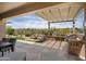Outdoor patio area with built-in grill, pergola and a rock waterfall surrounded by desert landscaping, perfect for entertaining at 28375 N 130Th Dr, Peoria, AZ 85383