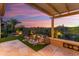 Relaxing backyard with a charming rock waterfall feature, desert landscaping, and a covered patio overlooking desert views at 28375 N 130Th Dr, Peoria, AZ 85383