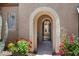 Inviting entryway with an arched gate, colorful flowers, and a charming, welcoming atmosphere at 28375 N 130Th Dr, Peoria, AZ 85383
